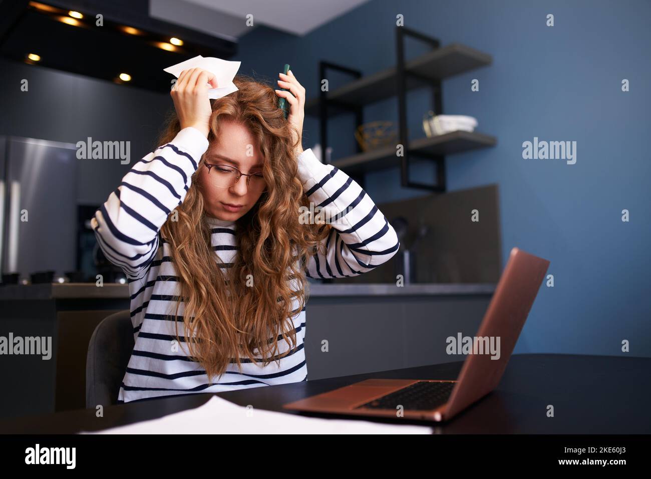 Une femme stressée calcule les dépenses sur les factures, contrariée par l'augmentation des prix des services publics. Recepts de comptabilité féminine, chèques de revenu, dettes, prêts à Banque D'Images