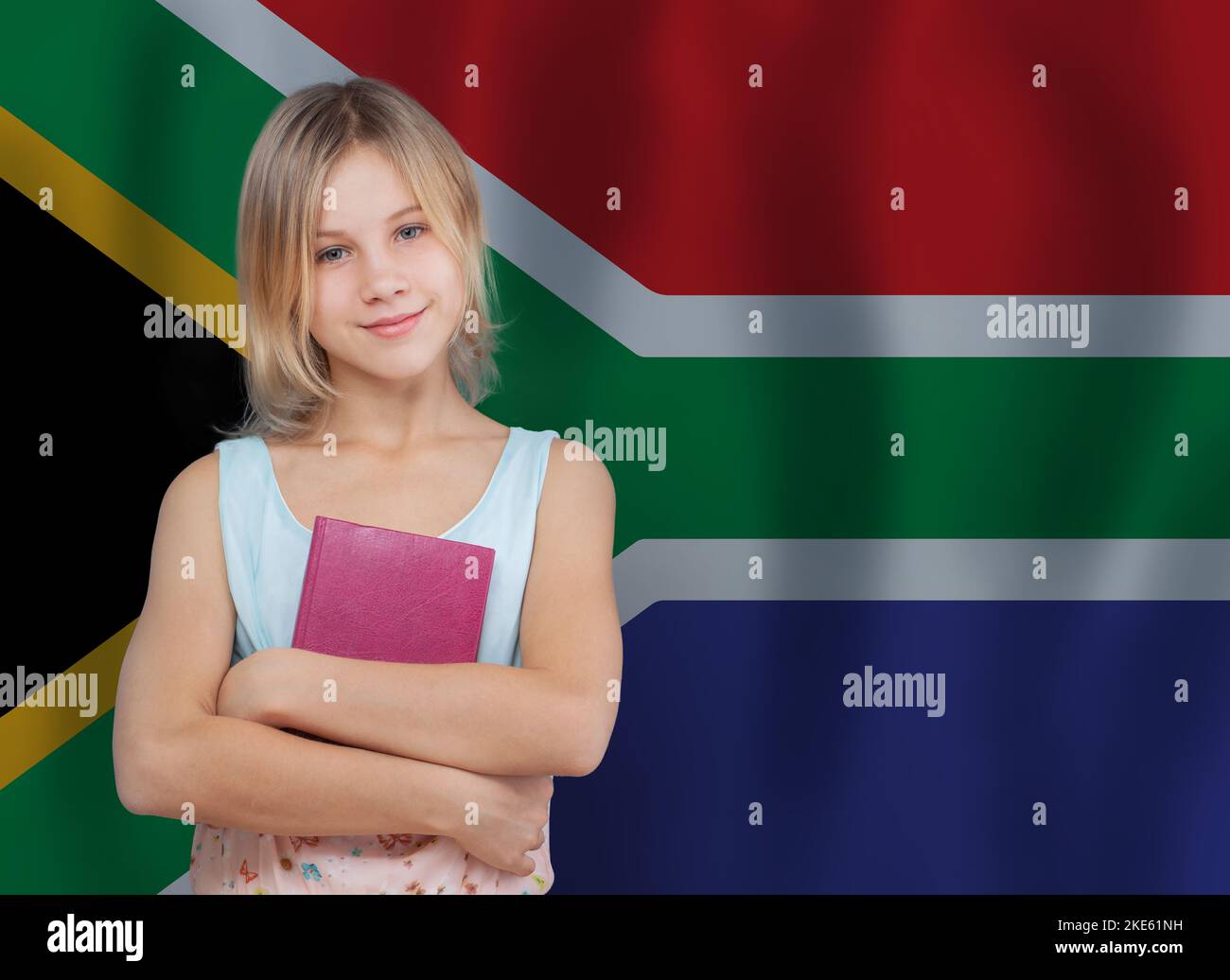 Bonne préadolescence jeune fille élève avec livre sur le drapeau de l'Afrique du Sud fond Banque D'Images