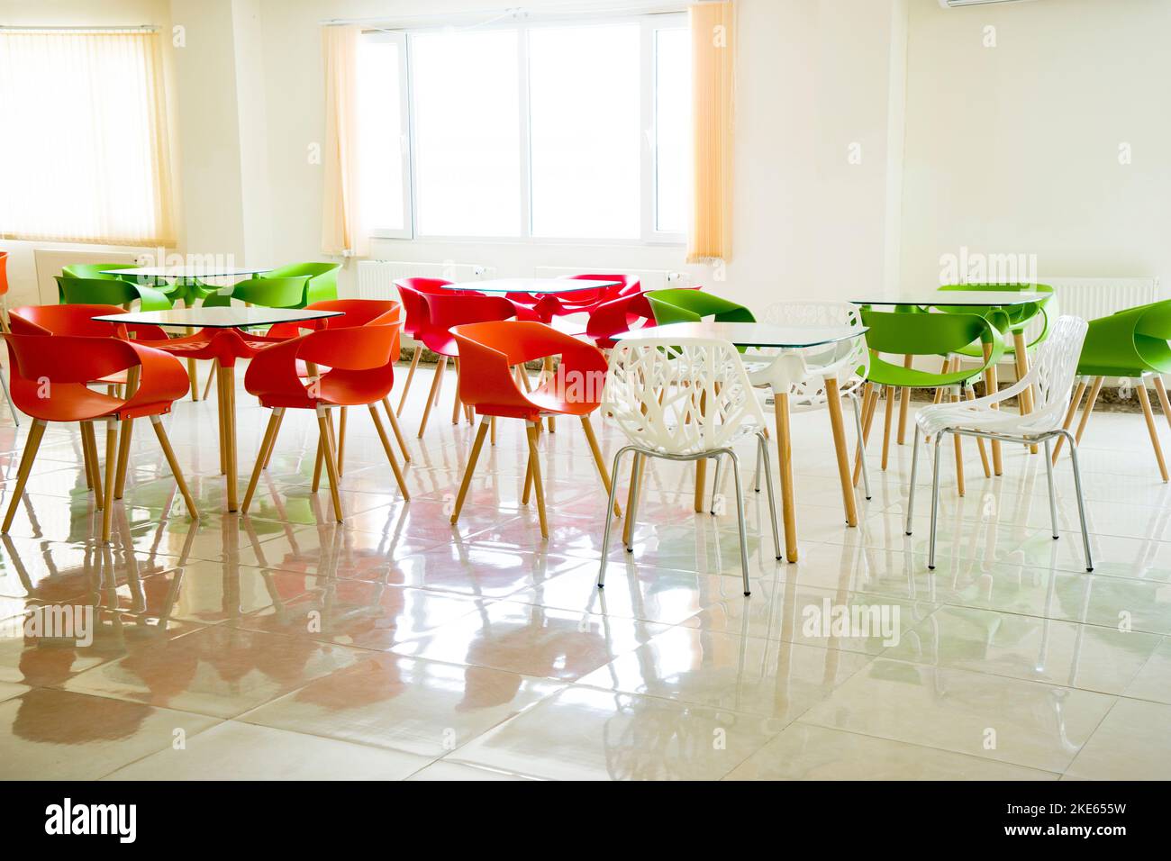 tables et chaises en plastique rouge, jaune et vert dans le café, dans la salle à manger. Banque D'Images