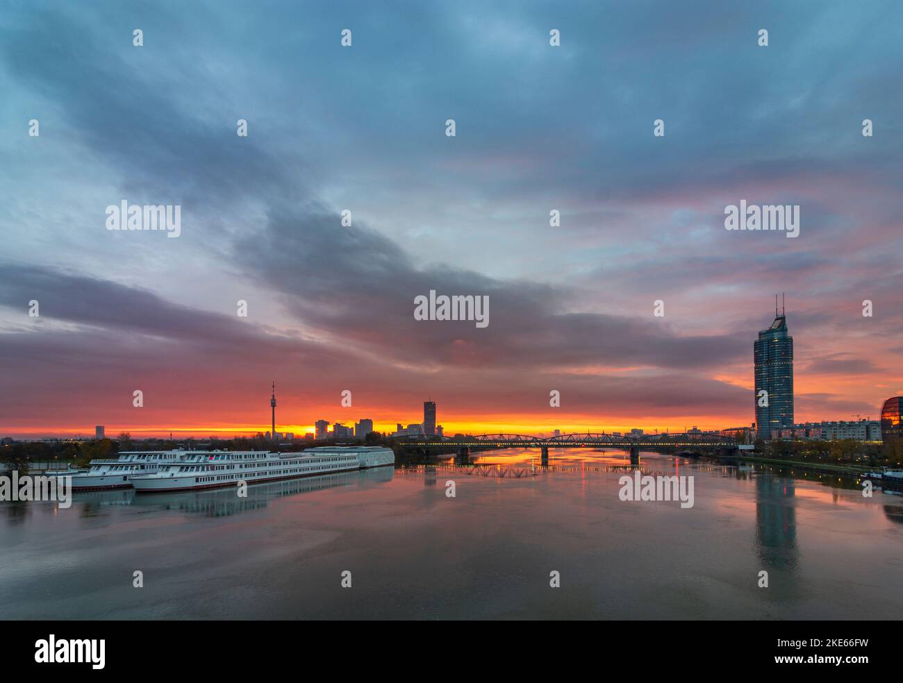 Wien, Vienne: rivière Donau (Danube) au lever du soleil, pont ferroviaire Nordbahnbrücke, tour Donauturm, Donaucity avec DC Tower 1, Millennium Tower, School shi Banque D'Images