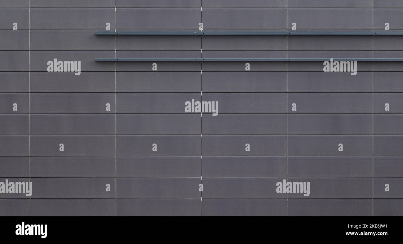 Vue de face d'un mur ou d'un bâtiment neuf et moderne en dalles grises. Arrière-plan abstrait haute résolution plein format texturé. Banque D'Images