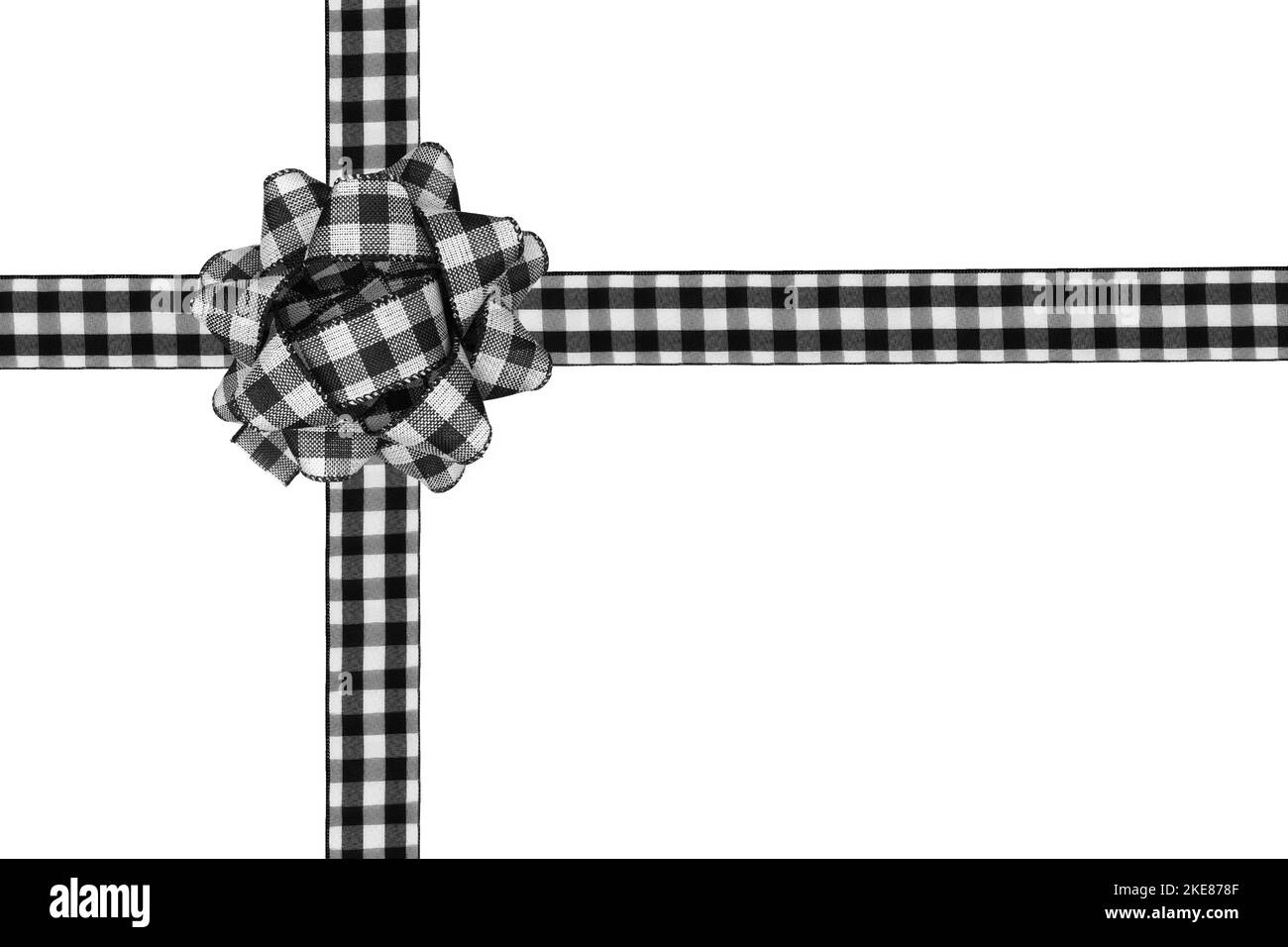 Un noeud et un ruban de Noël noir et blanc à motif écossais de buffle sont disposés comme une boîte cadeau isolée sur un fond blanc Banque D'Images Un noeud et un ruban de Noël noir et blanc à motif écossais de buffle sont disposés comme une boîte cadeau isolée sur un fond blanc Banque D'Images