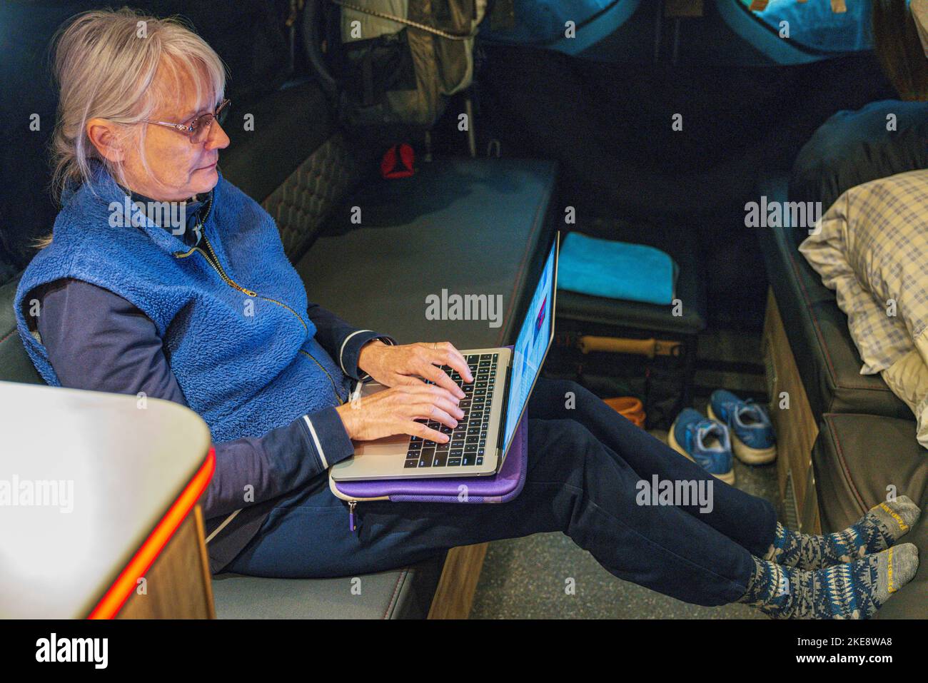 Femme senior travaillant sur ordinateur portable à l'intérieur d'Airstream Interstate 24X 4WD campervan; Morgan's Landing State Recreation site; Kenai Peninsula; Sterling; Alask Banque D'Images