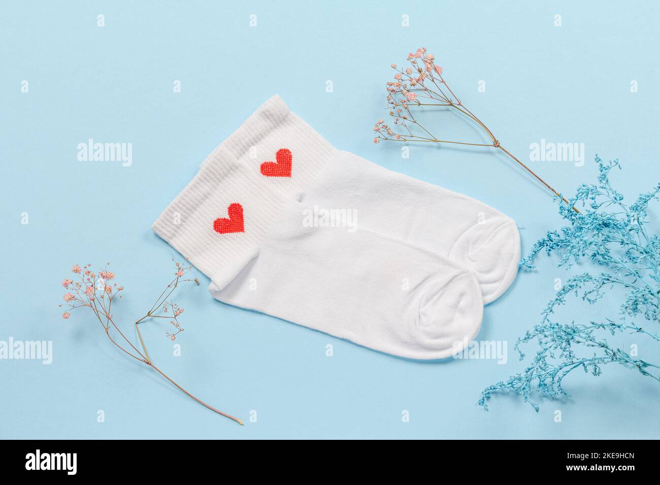Paire de chaussettes femmes blanches sur fond bleu. Banque D'Images