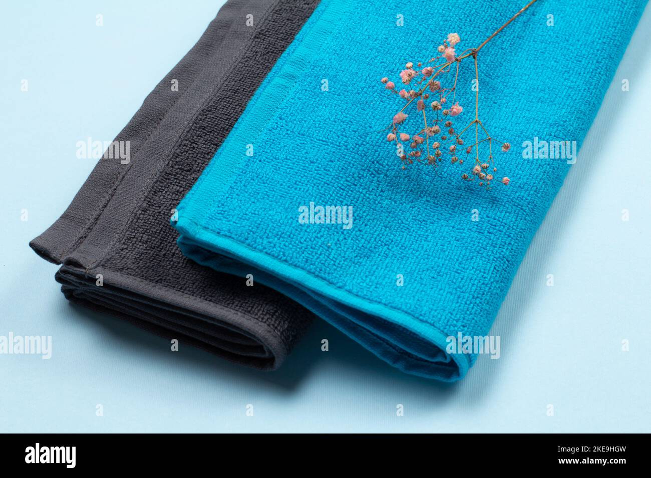 Pile de serviettes éponge douces sur fond bleu. Banque D'Images