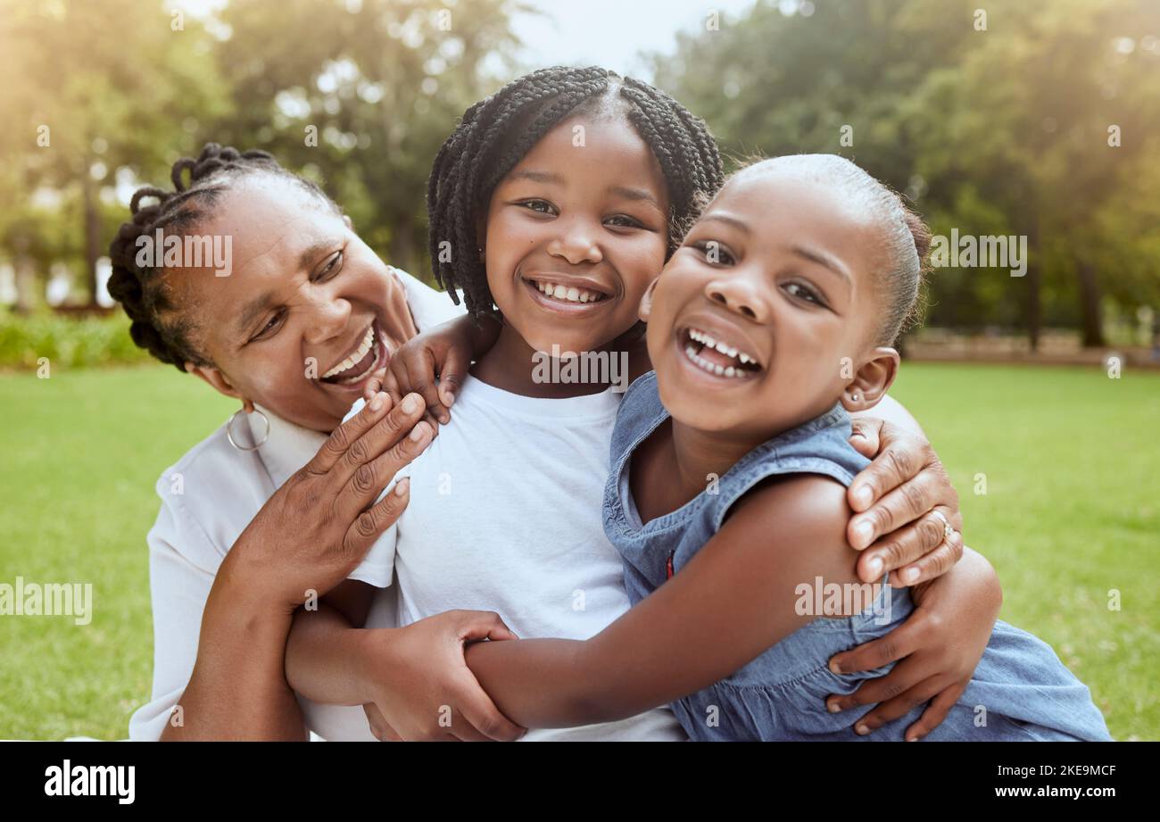 L'amour, la famille noire et la grand-mère avec les enfants profitent de temps de qualité en plein air ensemble, la paix ou la liberté du parc naturel. Enfants amusants, lien et portrait de Banque D'Images