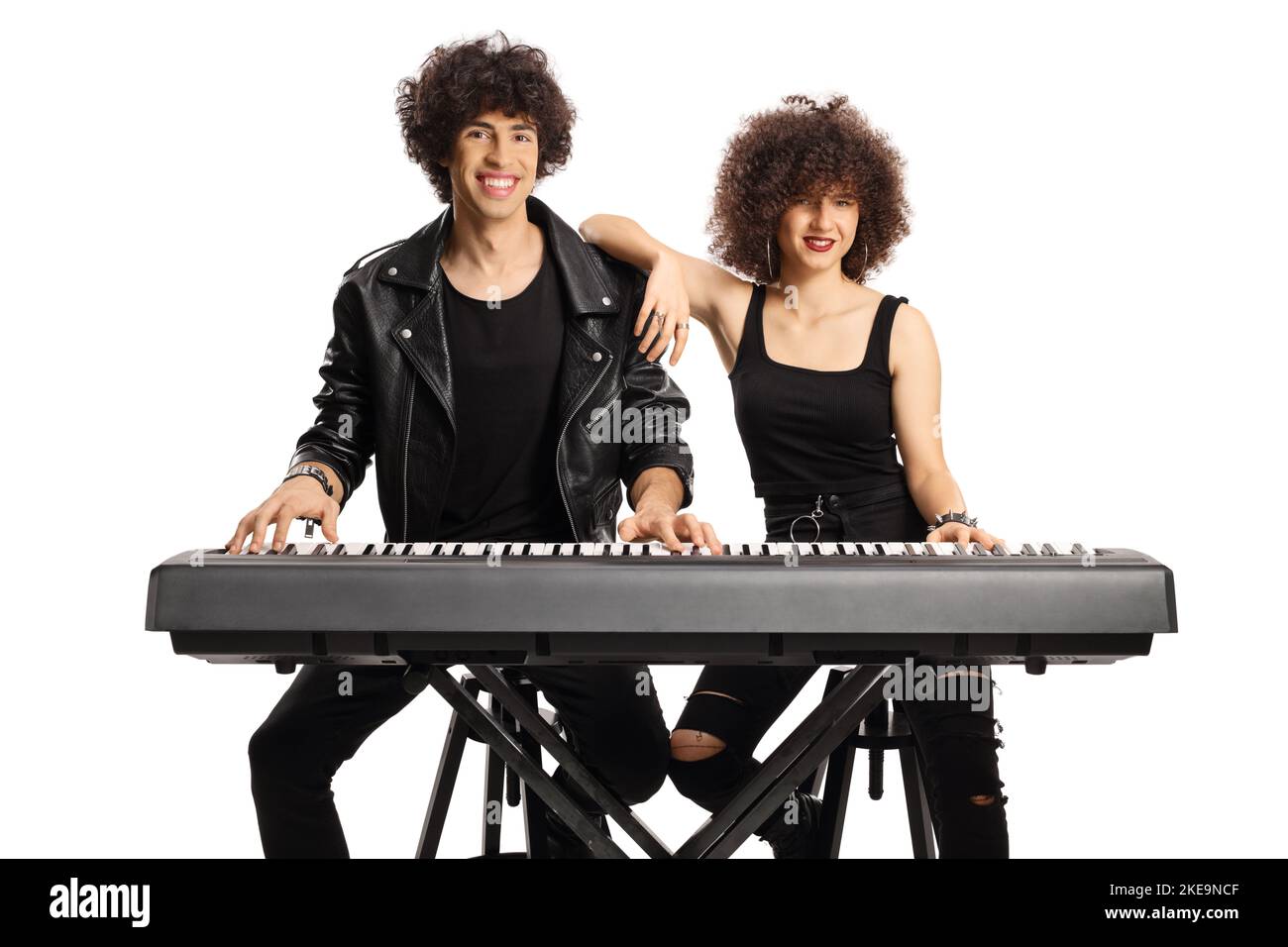 Jeune homme et femme aux cheveux bouclés posant avec un piano numérique isolé sur fond blanc Banque D'Images