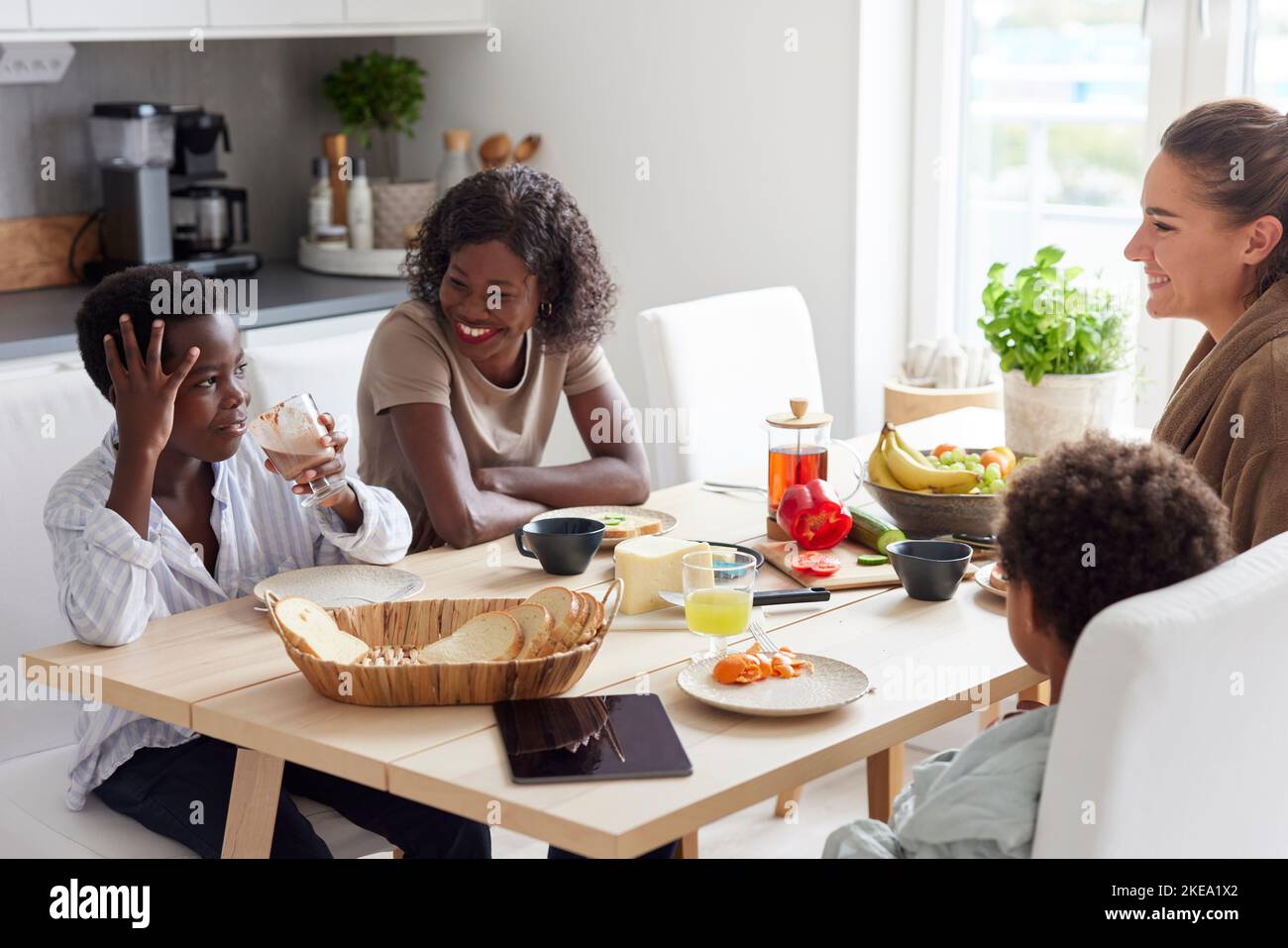 La famille est assise à table et prend le petit déjeuner Banque D'Images