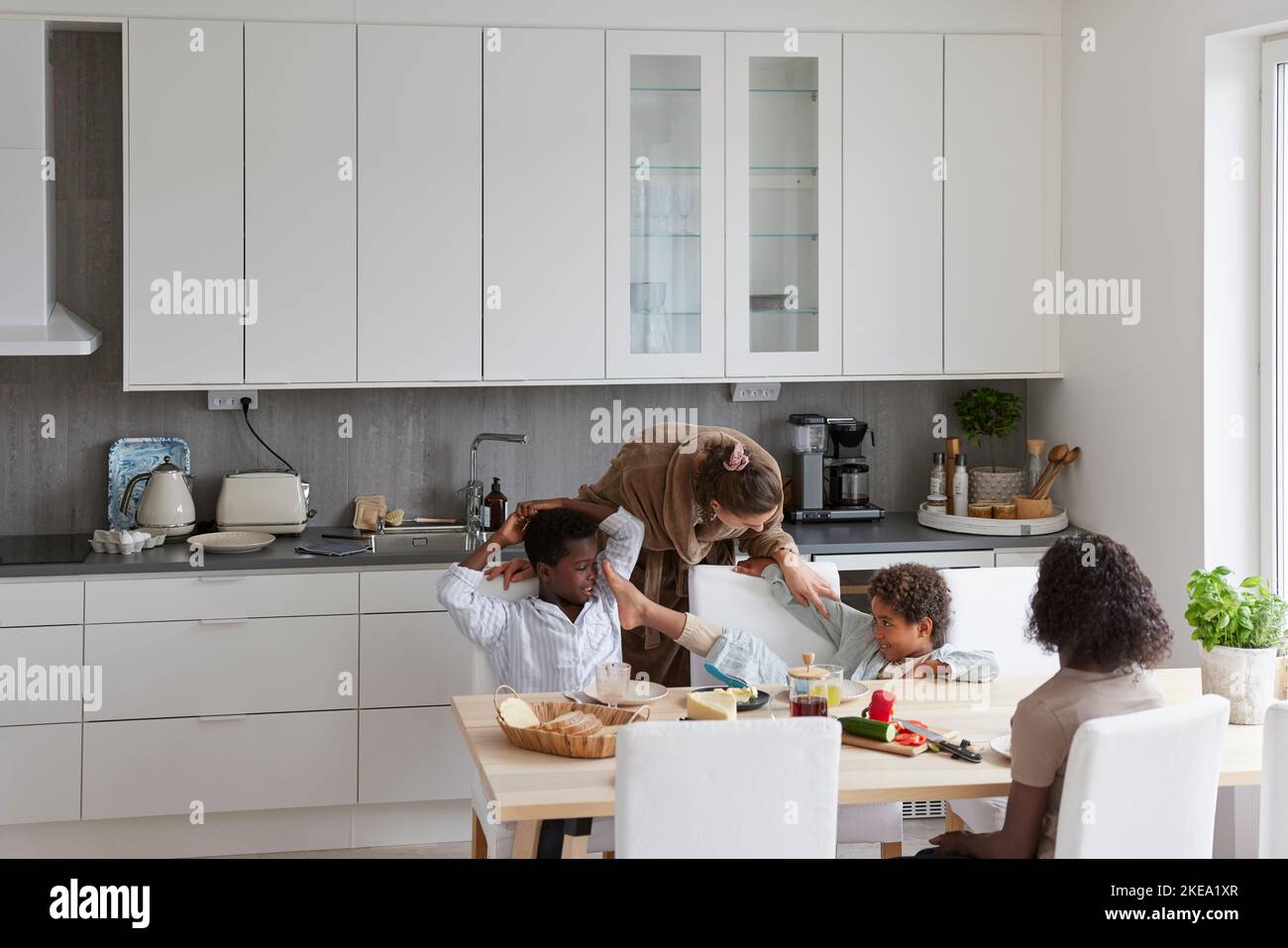 La famille est assise à table et prend le petit déjeuner Banque D'Images