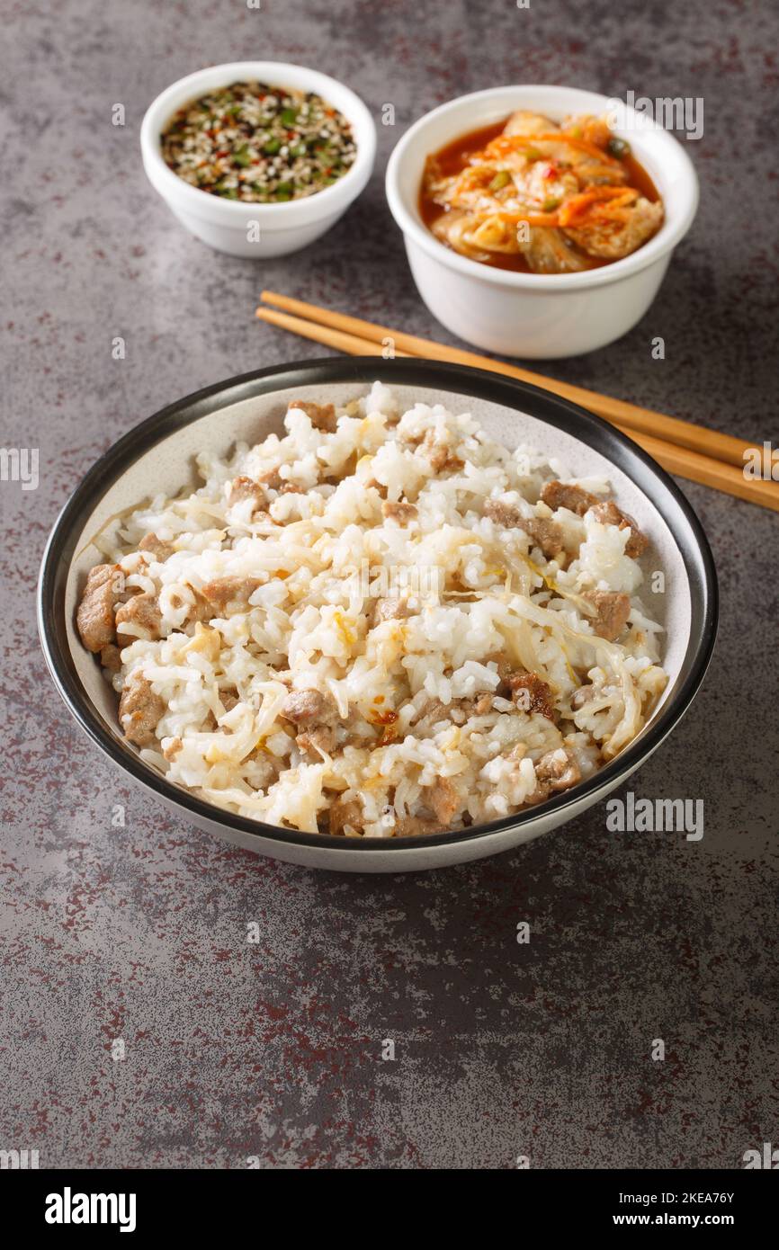 Riz coréen avec pousses de soja et viande servi avec sauce Yangnyumjang et kimchi en gros plan sur la table. Verticale Banque D'Images