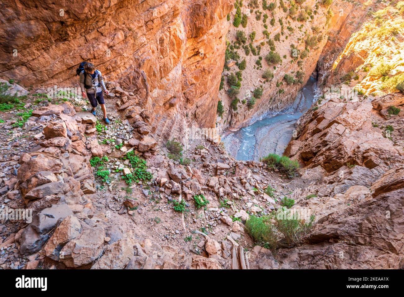 Un trekker sur un homme fait escalier sur le côté du canyon de la gorge m'Goun dans les montagnes de l'Atlas du Maroc Banque D'Images