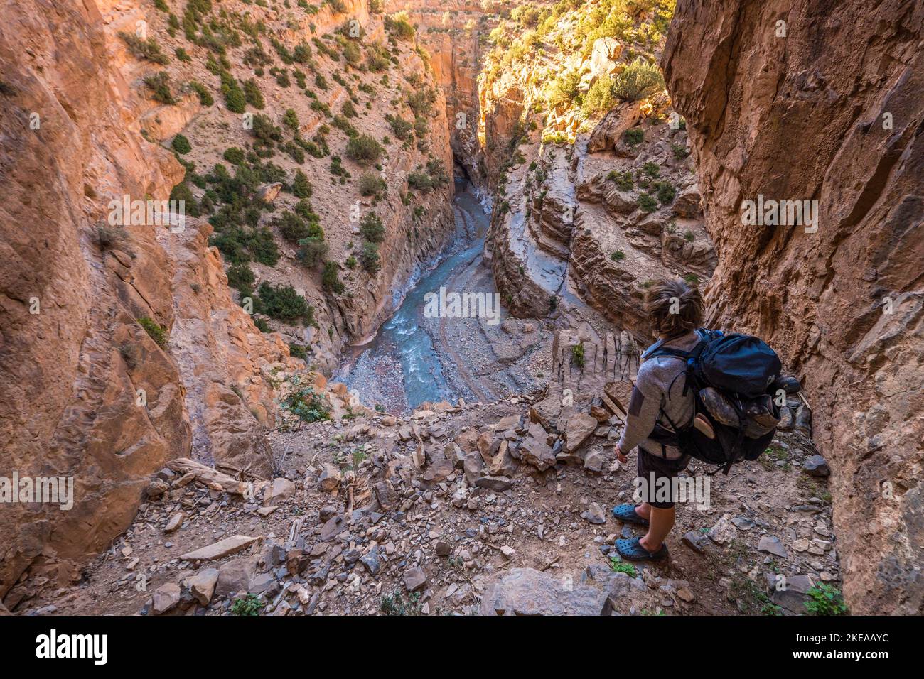 Un trekker sur un homme fait escalier sur le côté du canyon de la gorge m'Goun dans les montagnes de l'Atlas du Maroc Banque D'Images