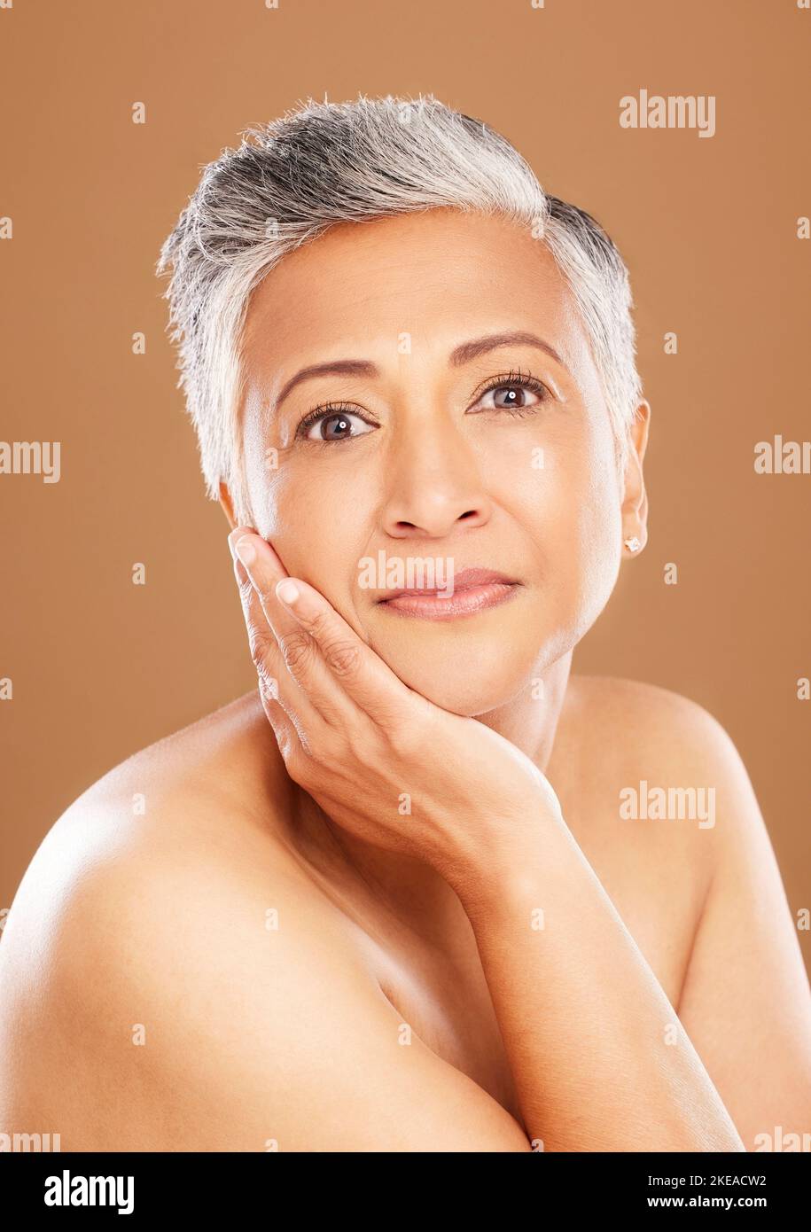 Soin de la peau, bien-être et portrait de femme noire senior isolée en studio sur fond orange. Beauté, cosmétiques et ancienne femme pose pour l'anti-vieillissement Banque D'Images