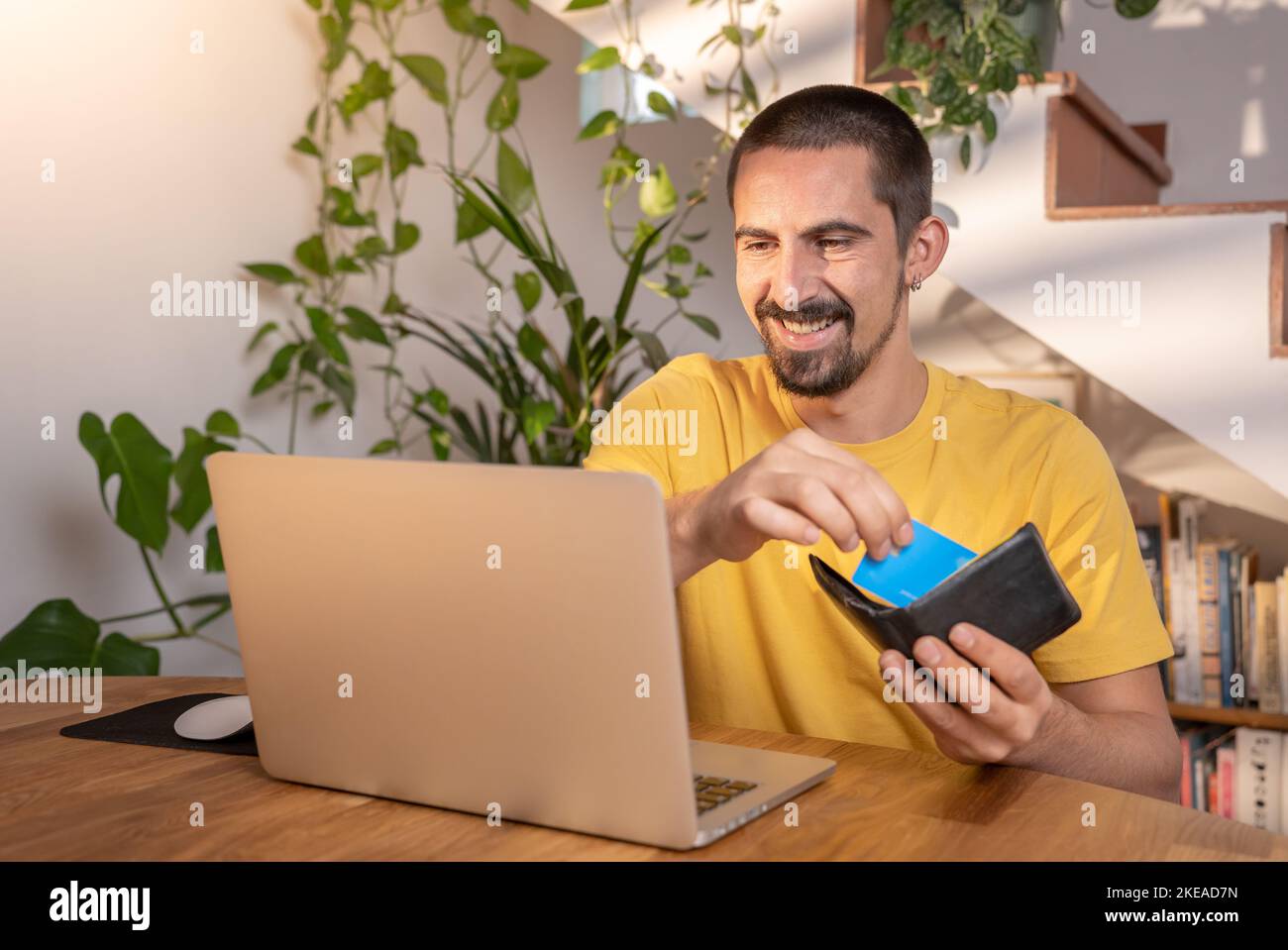 Homme payant avec carte de crédit sur ordinateur portable shopping en ligne au bureau à domicile. Banque D'Images