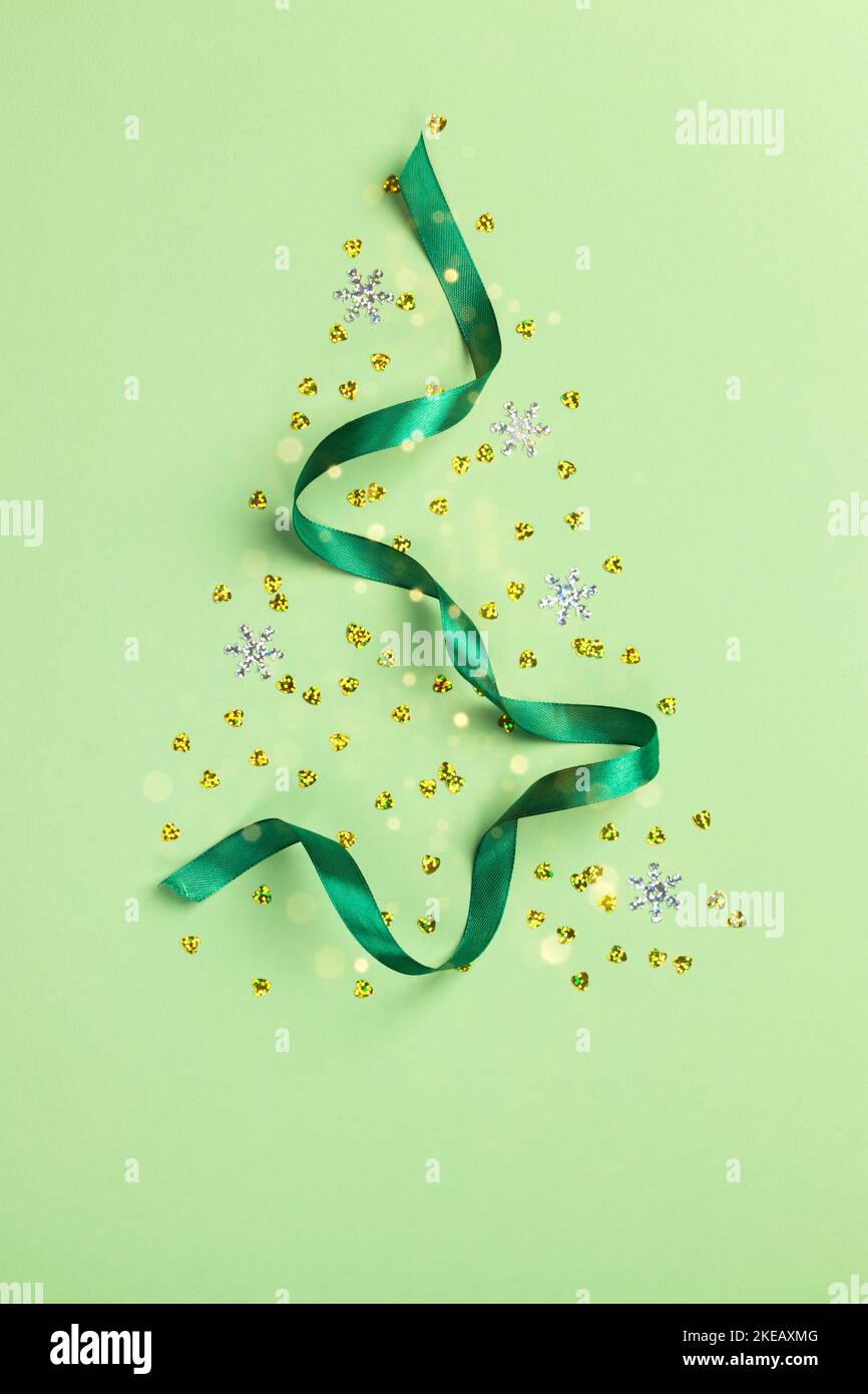 Carte de Noël avec coeurs confettis dorés et ruban en satin sur fond vert Banque D'Images