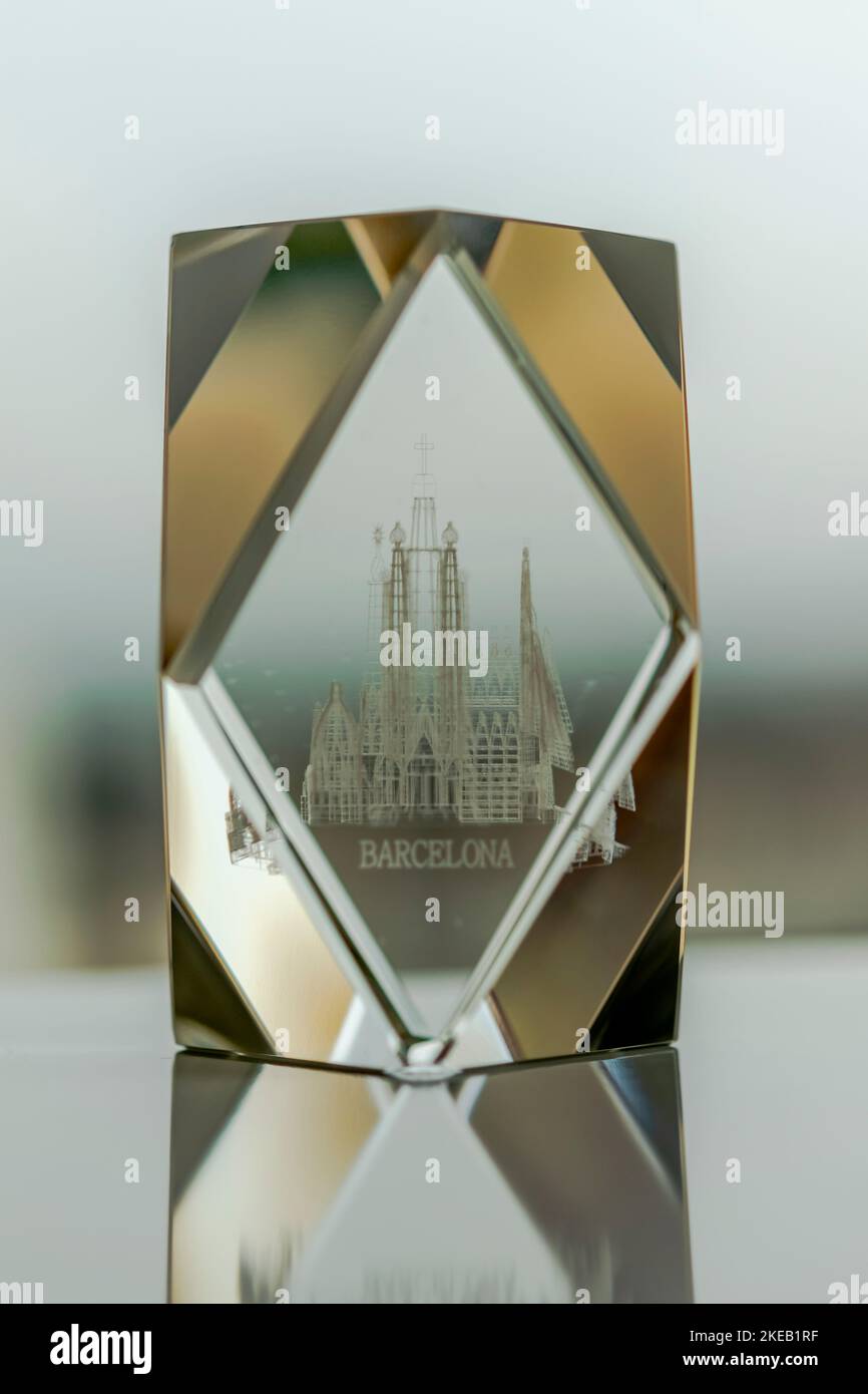 Le cercueil de la Sagrada Familia en verre se reflète sur une table blanche avec l'inscription de Barcelone et le monument sculpté à l'intérieur d'une forme de diamant. Banque D'Images