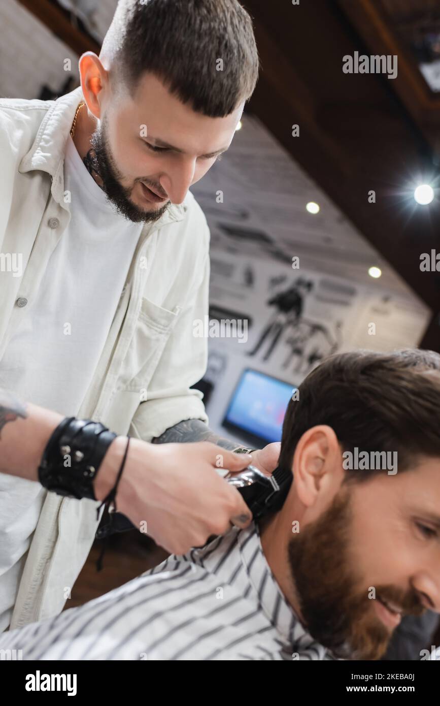 barbu coiffeur taille cheveux de client flou dans barbershop, image de stock Banque D'Images