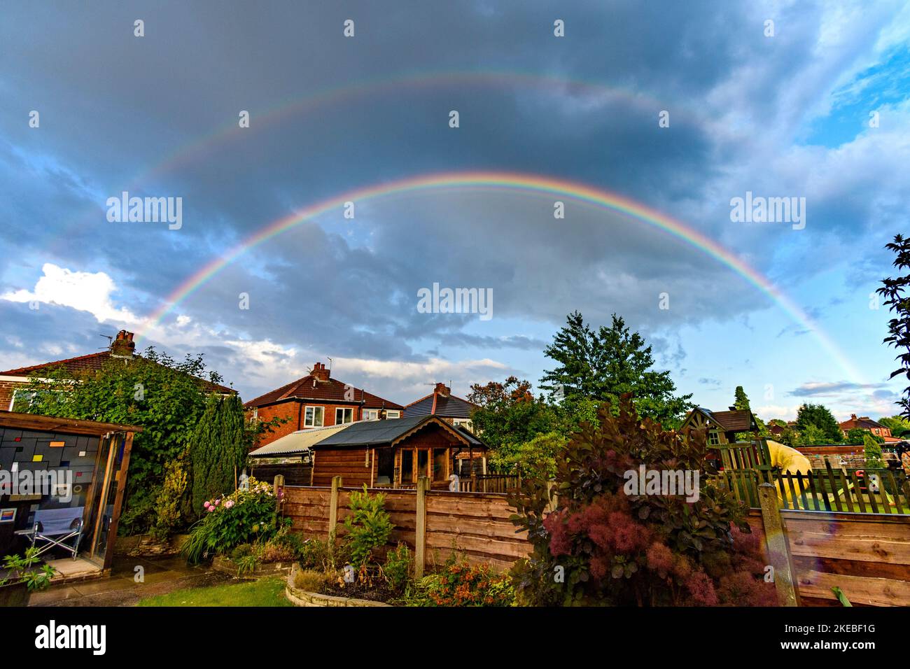 Double arc-en-ciel sur des maisons sur une propriété de banlieue, Tameside, Greater Manchester, Angleterre, Royaume-Uni Banque D'Images