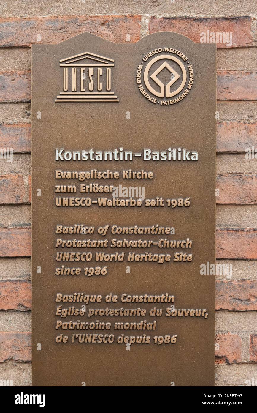 Grande vue rapprochée de la plaque métallique du site du patrimoine mondial de l'UNESCO, installée sur le mur de briques rouges de la célèbre basilique de Constantine à Trèves,... Banque D'Images