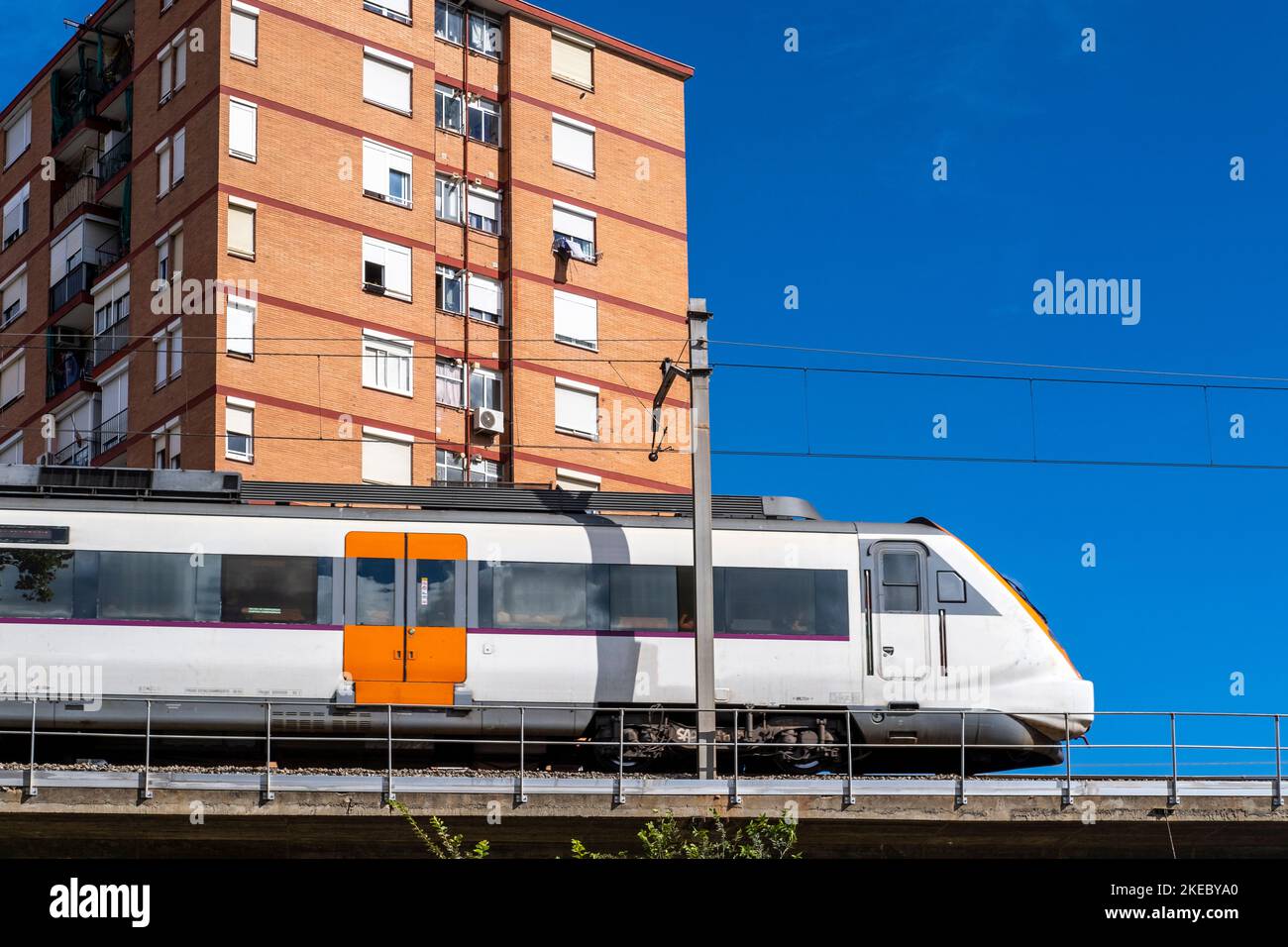 Train de banlieue sur un pont surélevé dans un quartier d'appartements ...