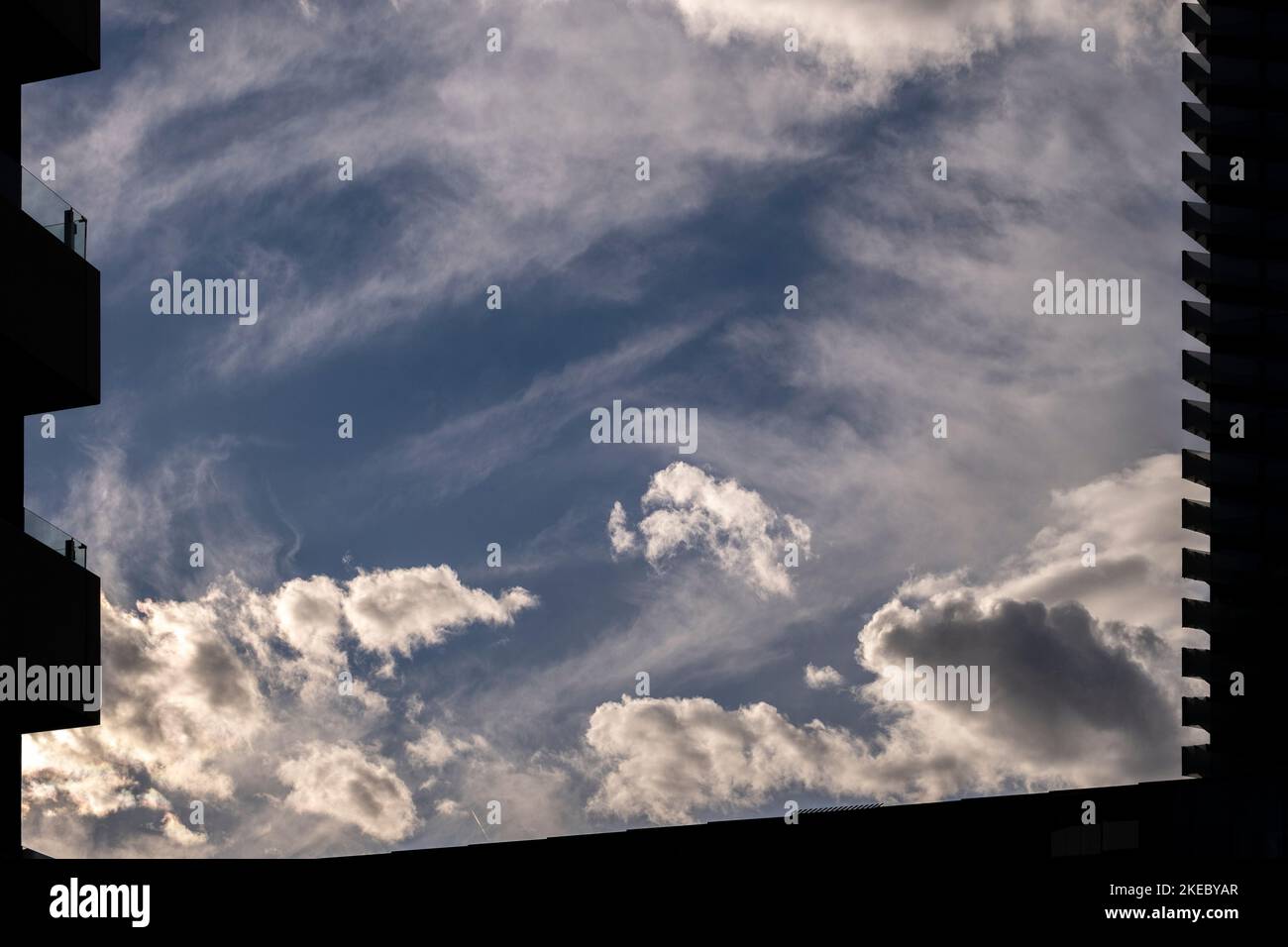 Vue sur le ciel avec des nuages entre silhouettes de bâtiments modernes Banque D'Images
