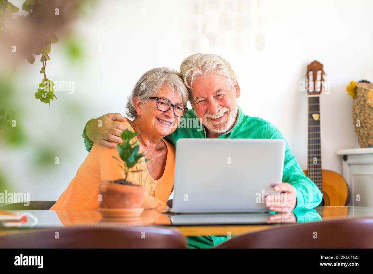 couple de deux personnes matures et âgées heureux ou aînés à la maison assis sur le canapé profiter et s'amuser ensemble en regardant et en utilisant un ordinateur portable ou un pc d'ordinateur Banque D'Images