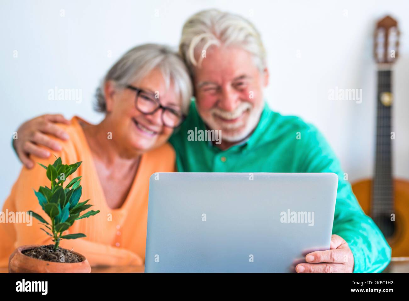 couple de deux personnes matures et âgées heureux ou aînés à la maison assis sur le canapé profiter et s'amuser ensemble en regardant et en utilisant un ordinateur portable ou un pc d'ordinateur Banque D'Images