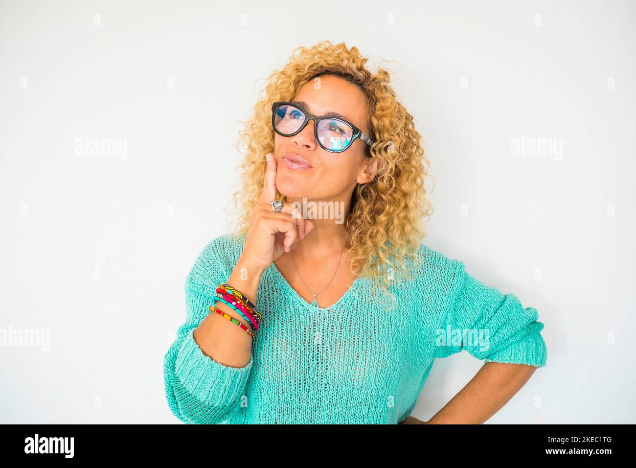 portrait d'une belle femme maurique pensant et rêvant - gros plan de personnes rêveuses portant des lunettes et une chemise bleue avec un fond blanc Banque D'Images