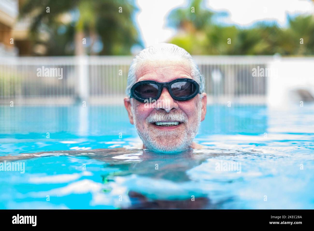 gros plan sur le visage de l'homme âgé ou adulte nageant et s'amusant à la piscine - entraînement et s'amuser seul Banque D'Images