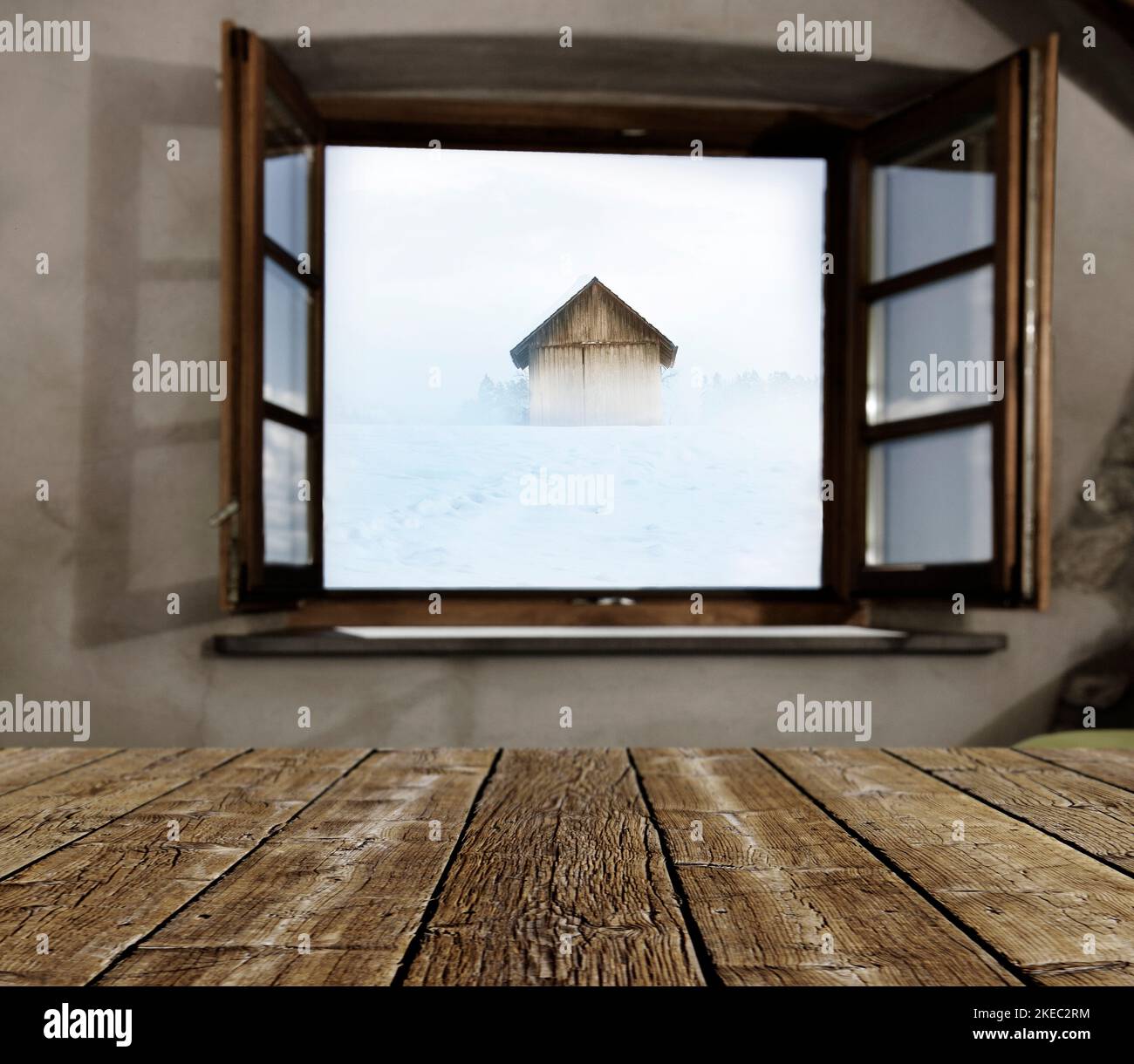 Vue par une fenêtre ouverte sur un paysage enneigé avec hangar en bois Banque D'Images