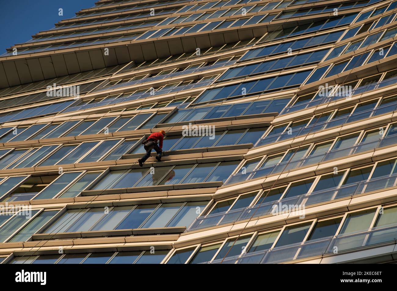 Un homme lave les fenêtres d'un gratte-ciel. Alpinisme industriel. Banque D'Images Un homme lave les fenêtres d'un gratte-ciel. Alpinisme industriel. Banque D'Images