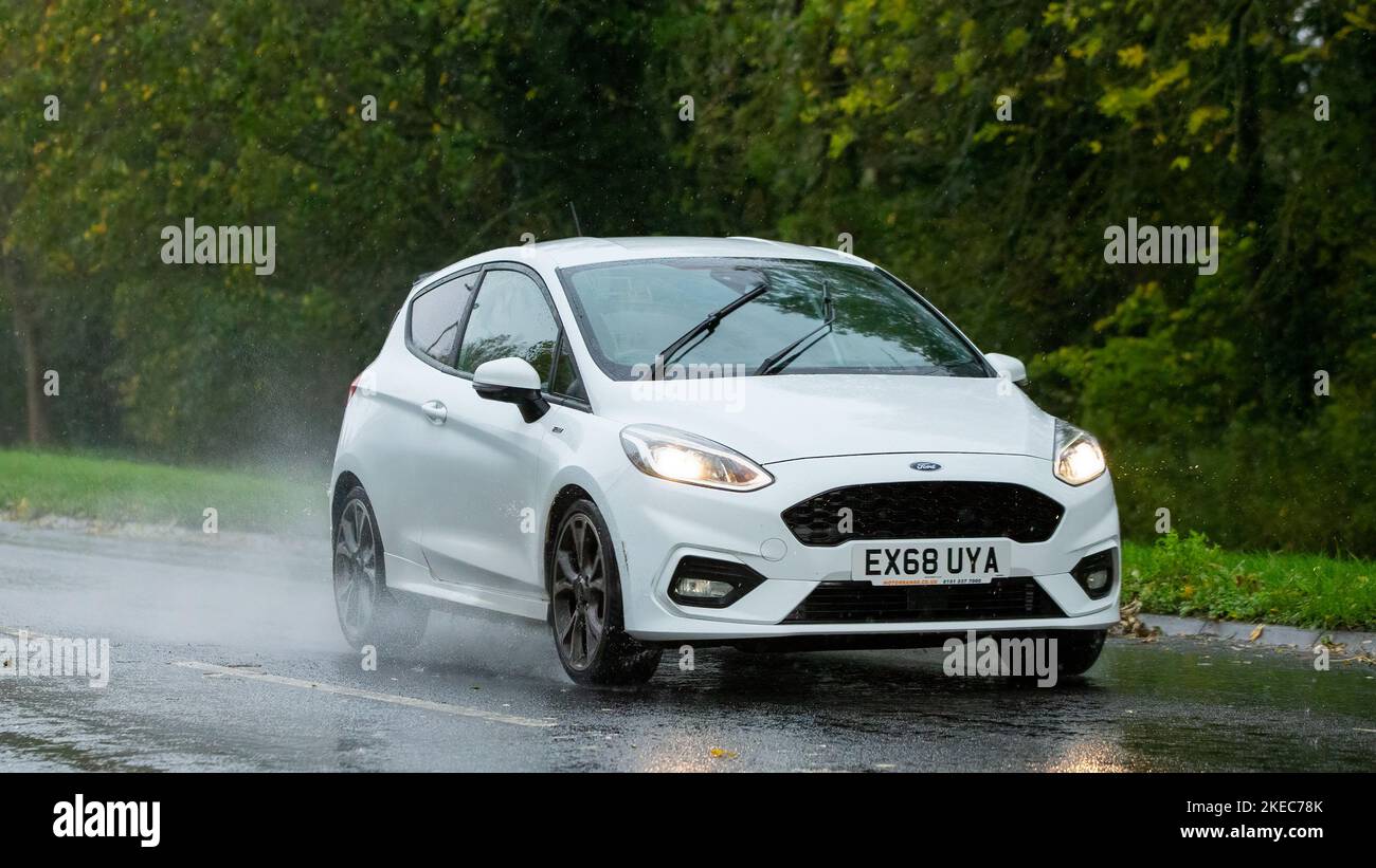 2018 Ford Fiesta blanc conduite sous la pluie sur une route humide Banque D'Images