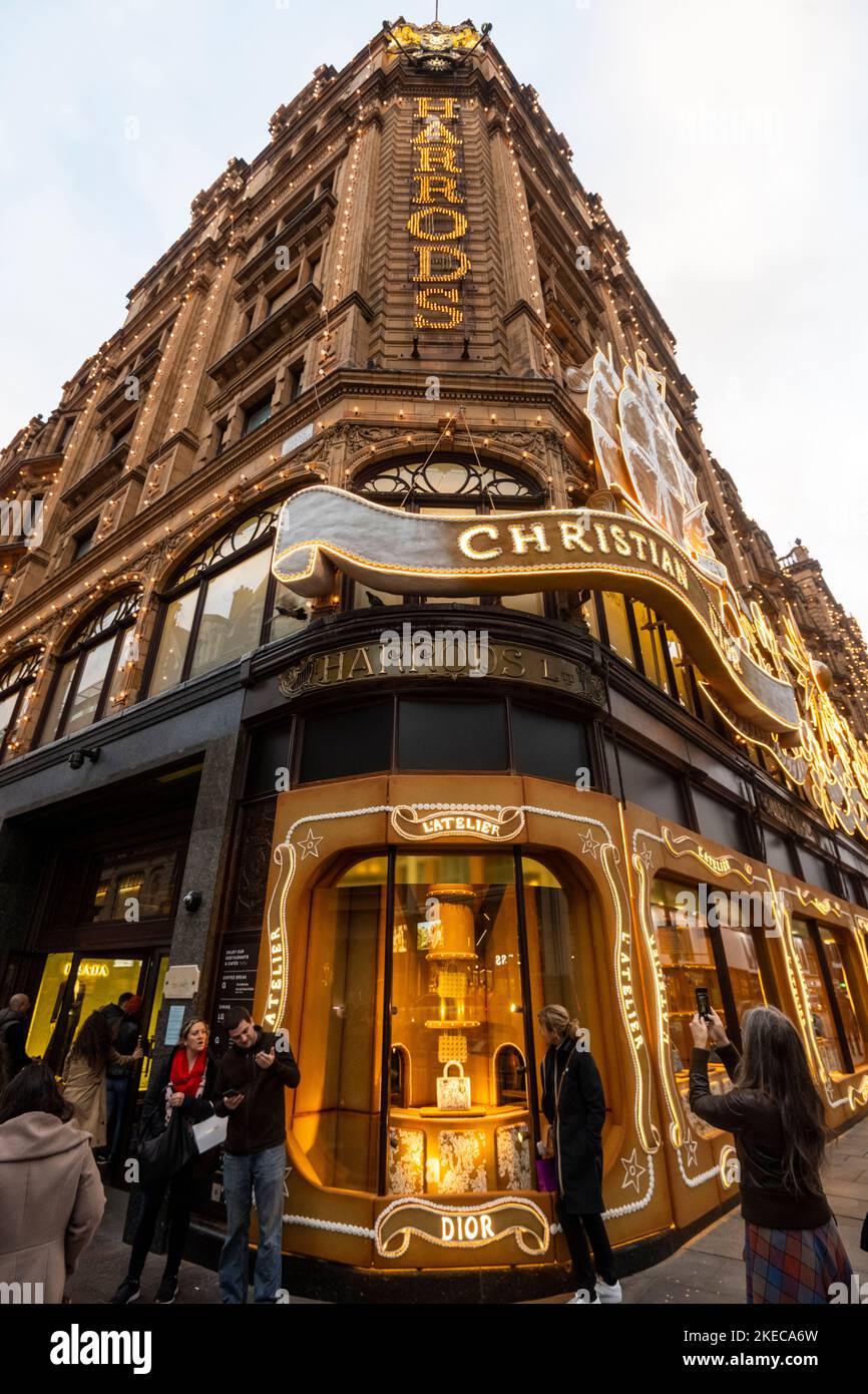 Londres, Royaume-Uni. 11 novembre 2022. Les gens passent devant le grand magasin Harrods de Knightsbridge, qui a reçu un relooking interne et externe pour Noël. L'extérieur et les vitrines ont été décorés en hommage au designer Christian Dior, la première fois qu'un message aussi vaste a été incorporé dans les décorations annuelles. Les fenêtres du magasin comprennent un thème de pain d'épice qui continue à l'intérieur. Credit: Stephen Chung / Alamy Live News Banque D'Images