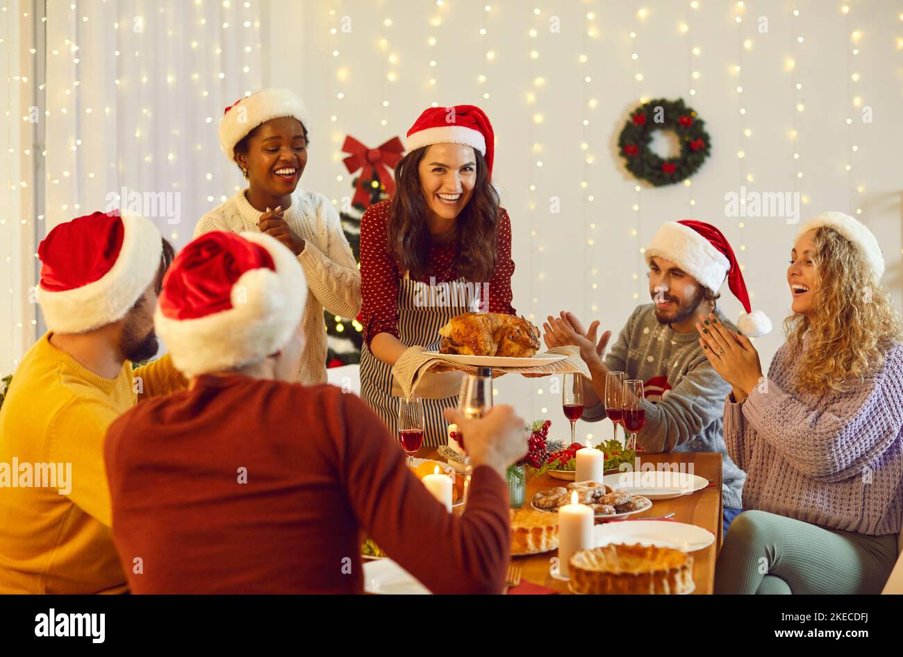 Des gens souriants se rassemblent pour le dîner de Noël à la maison Banque D'Images