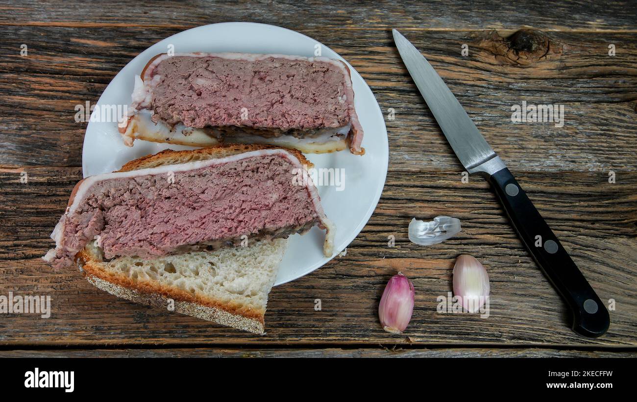 Pâté fait maison enveloppé de bacon de porc et de foie sur une table rustique Banque D'Images