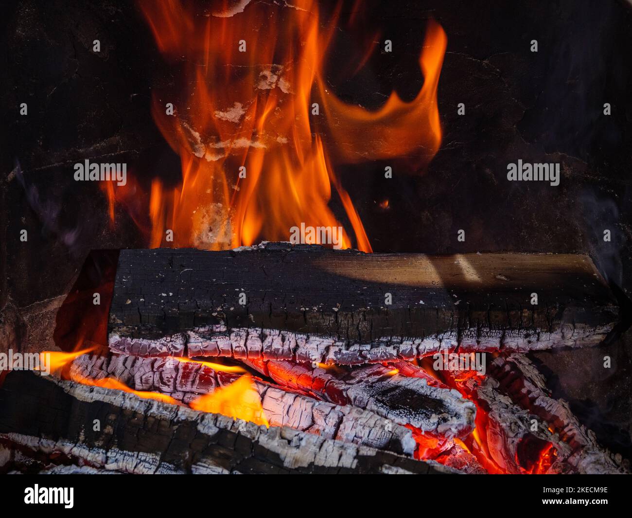 Bois de chauffage brûlant dans une cheminée avec des ébres et des langues de flamme Banque D'Images