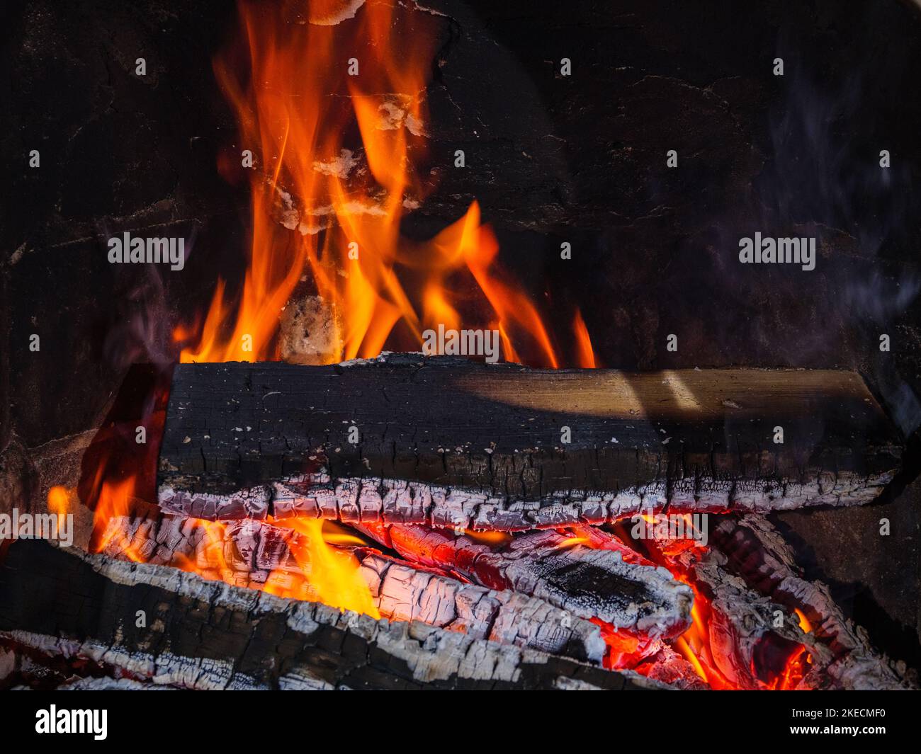Bûches dans la cheminée avec des ébres, de la chaleur et des flammes Banque D'Images