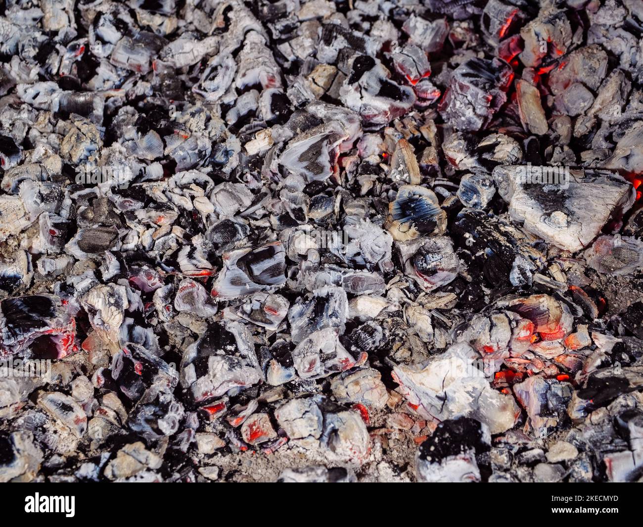 Des émbres orange à couver dispersés dans une couche uniforme comme arrière-plan Banque D'Images