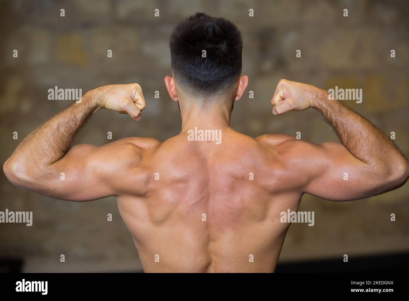 vue arrière du bodybuilder fléchissant ses muscles Banque D'Images