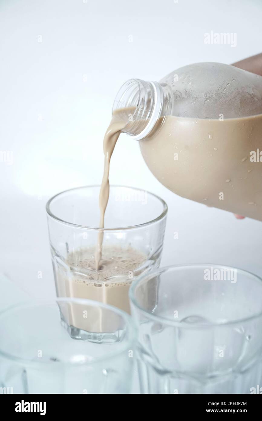 verser le lait au chocolat dans un verre Banque D'Images