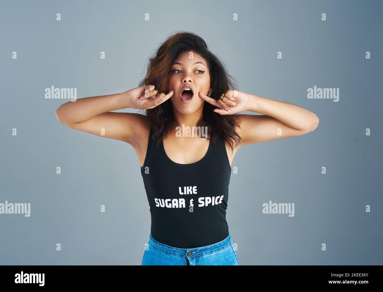 Oh mon. Une jeune femme attrayante posant sur un fond gris. Banque D'Images