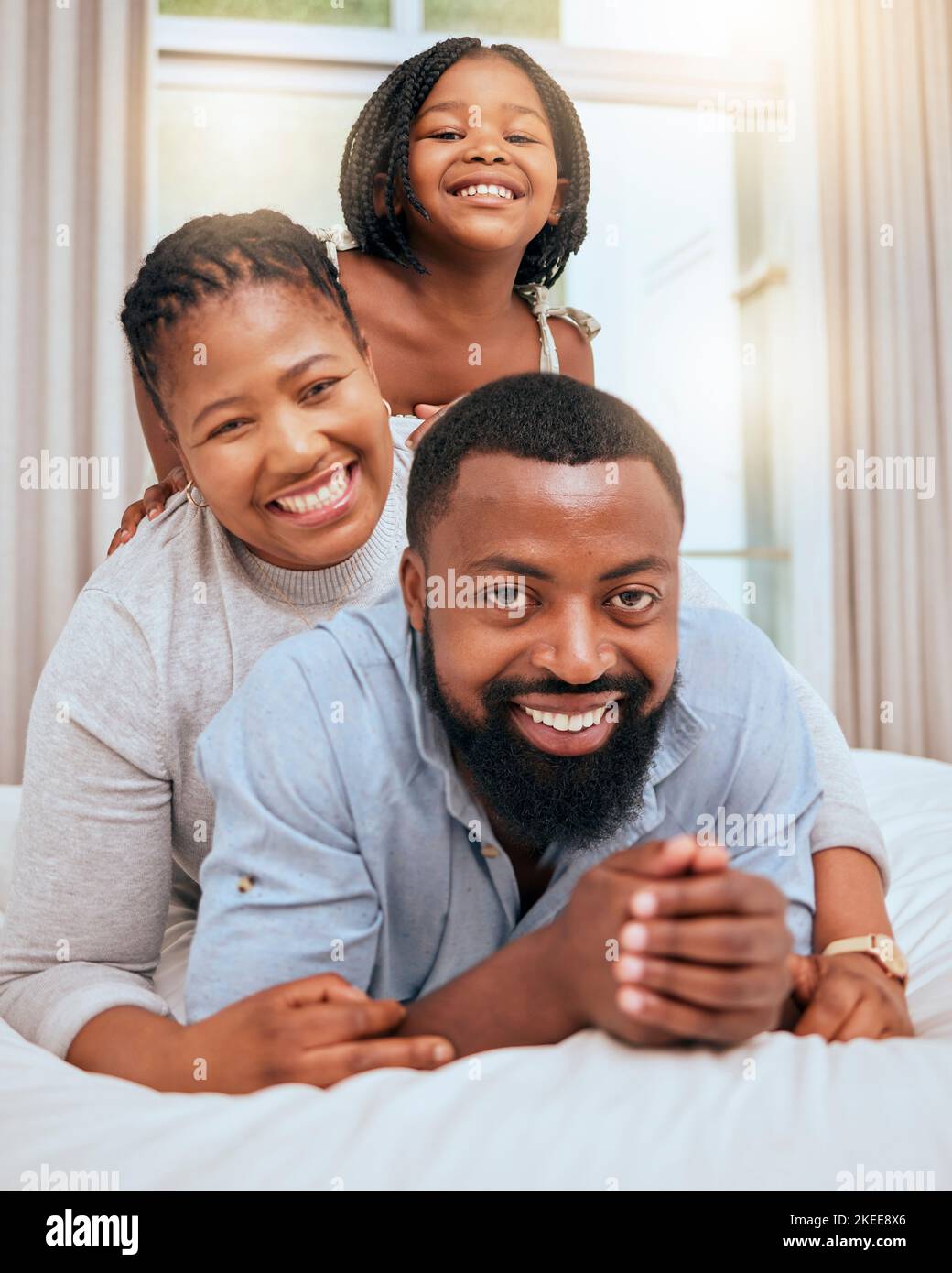 L'amour, la famille noire et avec une fille au lit, heureux ou sourire ensemble pour le collage, l'amour et le plaisir. Portrait, mère et père ou parents avec fille Banque D'Images