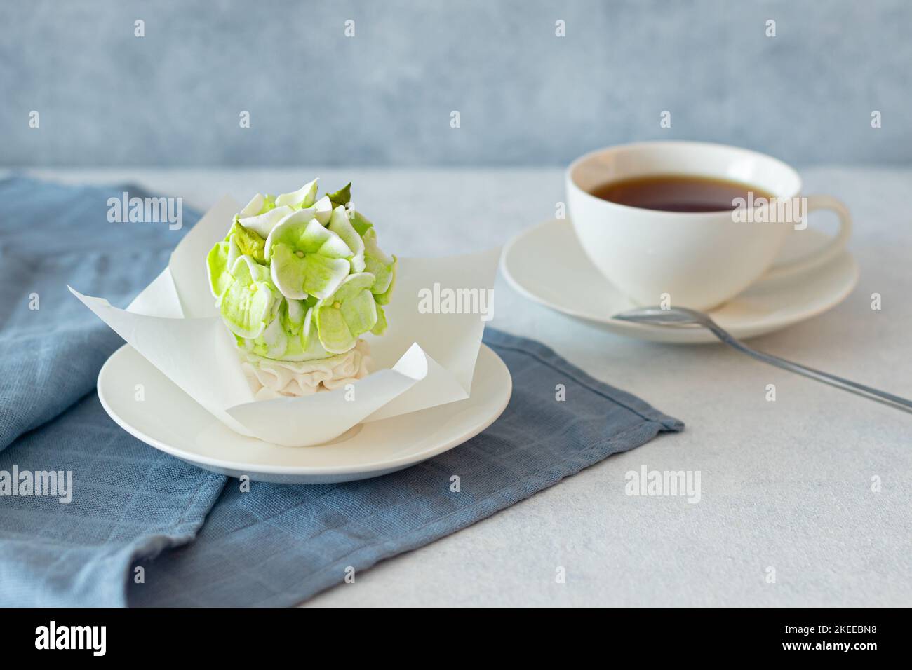 ensemble de thé dans une composition avec des fleurs de guimauve. Tasse à café sur soucoupe. Sur fond gris clair. Soirée thé revigorante le matin Banque D'Images