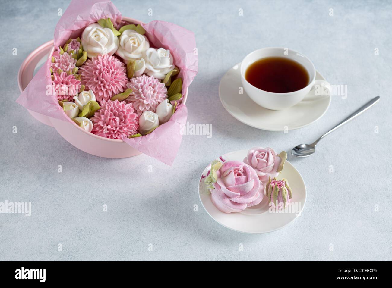 ensemble de thé dans une composition avec des fleurs de guimauve. Tasse à café sur soucoupe. Sur fond gris clair. Soirée thé revigorante le matin Banque D'Images