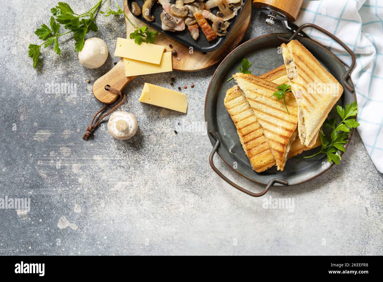 Délicieux sandwich club, fromage grillé maison, sandwich au bacon et aux champignons pour le petit déjeuner sur une table en pierre. Vue de dessus. Copier l'espace. Banque D'Images