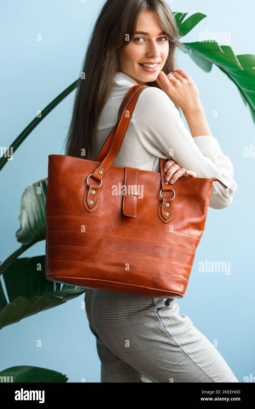photo en gros plan d'un sac en cuir orange dans les mains des femmes Banque D'Images