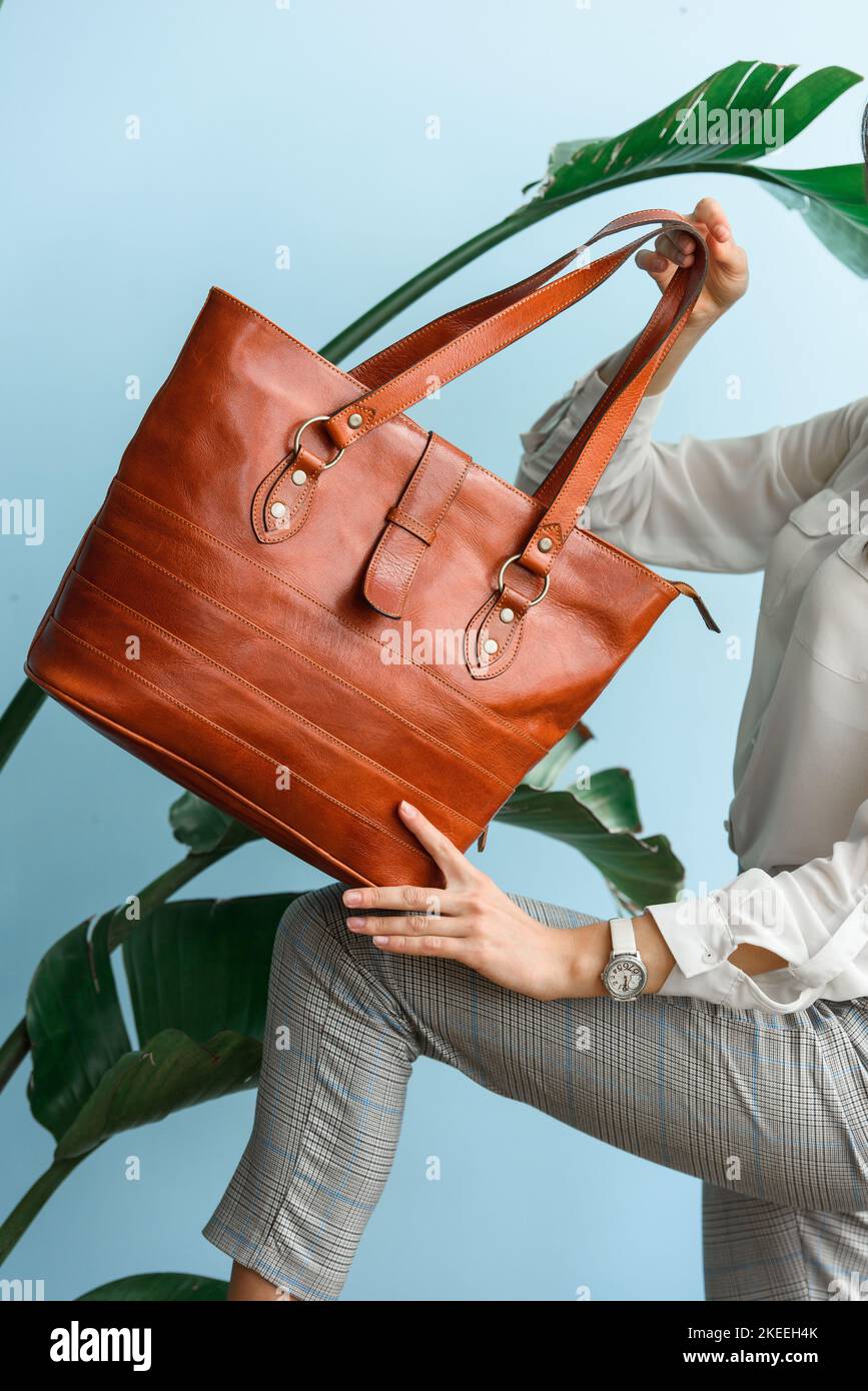 photo en gros plan d'un sac en cuir orange dans les mains des femmes Banque D'Images