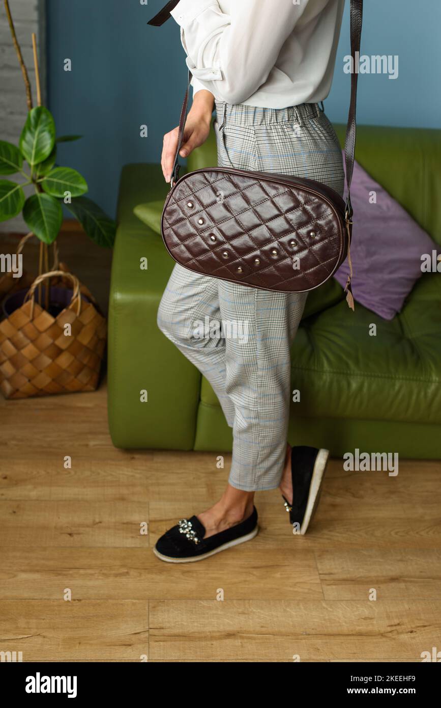 femme avec un petit sac en cuir marron avec un motif. Banque D'Images