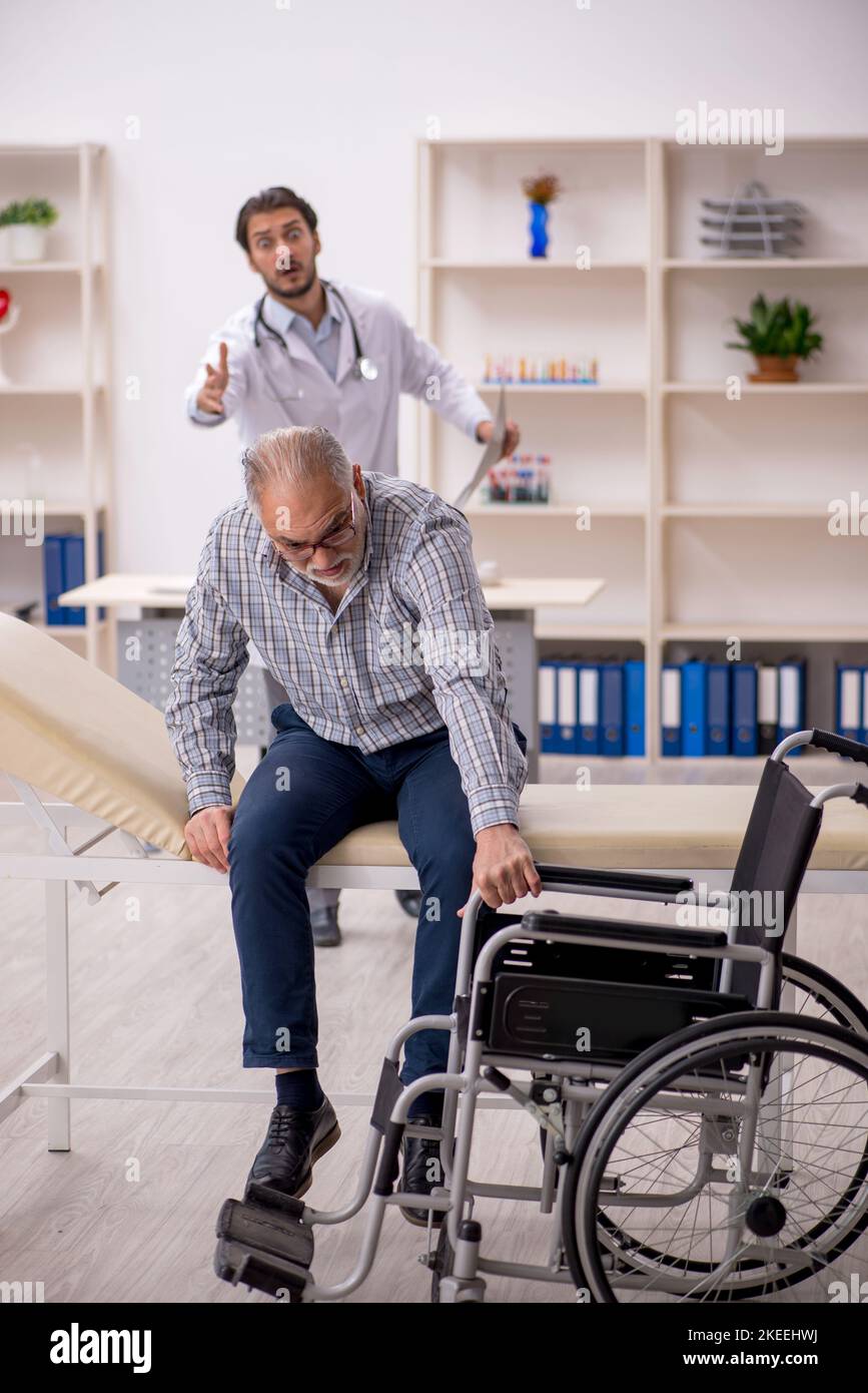 Un vieux homme en fauteuil roulant rend visite à un jeune homme médecin  Photo Stock - Alamy