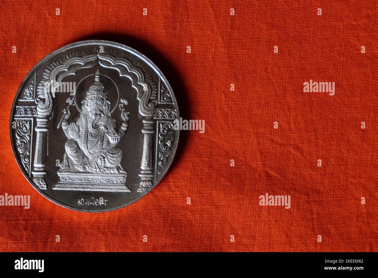 Lord Ganesha pièce d'argent sur un tissu de coton orange/STILL LIFE/Ganesh Chaturthi Banque D'Images